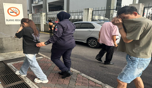 Tertuduh, Lee Yuen Fei dan Trieu Thi Mai, dikawal polis ketika tiba di mahkamah