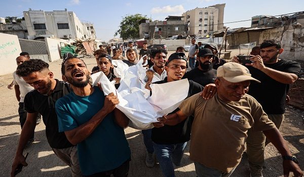 Mourners carry the body of one of three Palestinians during their funeral at Al Shifa Hospital in Gaza City on October 25, 2026, after they were killed in an Israeli strike on the Islamic University building. An Israeli strike on a university in Gaza City killed three people on October 25, staff and a local hospital said, while the civil defence agency reported four others killed elsewhere in the territory. Reached for comment, the Israeli military said it was looking into the reports. (Photo by Omar AL-QATTAA / AFP)
