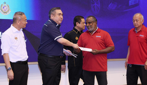Loke (dua dari kiri) menyampaikan baucar sumbangan RM1,000 kepada penerima / Foto Fail BERNAMA