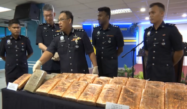 Ketua Polis Daerah Timur Laut, ACP Razlam menunjukkan ganja dibungkus dengan balutan emas yang disembunyikan dalam lubang kubur Cina di Mount Erskine di sini.