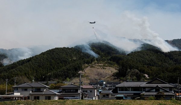A helicopter conducts firefighting operations as wildfires continue in Otsuchi, Iwate Prefecture, Japan, April 26, 2026. REUTERS/Kim Kyung-Hoon