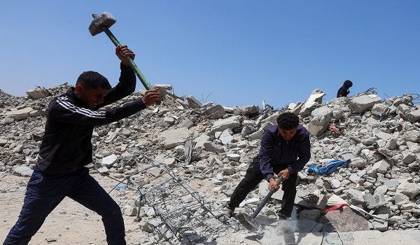 Palestinian workers break up concrete while working on rubble in Khan Younis, southern Gaza Strip, April 19, 2026. REUTERS/Ramadan Abed