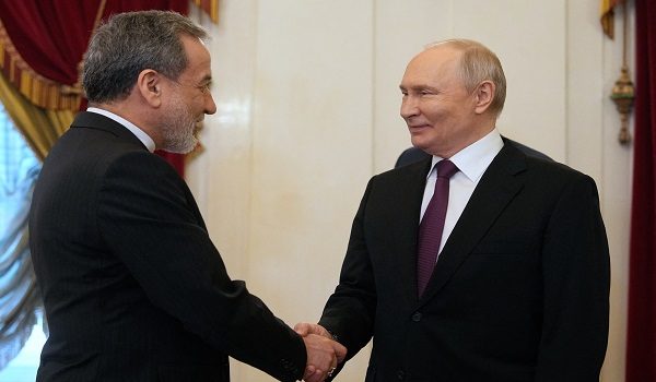 Russian President Vladimir Putin shakes hands with Iranian Foreign Minister Abbas Araghchi during their meeting at the Boris Yeltsin Presidential Library in Saint Petersburg on April 27, 2026. (Photo by Dmitry LOVETSKY / POOL / AFP)