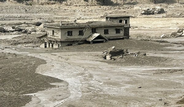 A house lies partially submerged in muddy water after flash floods at Trishuli Bazar in Nepal's Nuwakot district on August 26, 2026. A massive flood swept through Nepal's northern Rasuwa district on August 26, damaging roads and power infrastructure as authorities scrambled to assess the scale of the destruction. (Photo by Prakash MATHEMA / AFP)