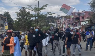 Seorang penunjuk perasaan mengibarkan bendera Madagascar ketika demonstrasi membantah gangguan bekalan air dan elektrik berulang kali di Antananarivo/ Foto AFP