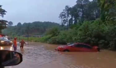 Kereta ke dalam longkang dipenuhi air banjir / Foto RTM