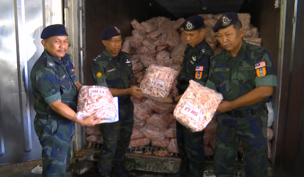Komander PGA Briged Utara, Penolong Kanan Pesuruhjaya Polis, SAC Shahrum Hashim (dua, kiri) menunjukkan kaki ayam sejuk beku yang dirampas di sebuah gudang di Padang Besar / Foto RTM