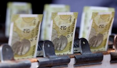 FILE PHOTO: Indian twenty rupee currency notes are displayed at a roadside currency exchange stall in New Delhi, India, May 24, 2024. REUTERS/Priyanshu Singh/File Photo