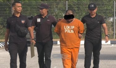 Tertuduh diiringi polis ketika tiba di mahkamah