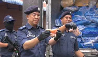 Pengarah JKDM Kelantan, Wan Jamal Abdul Salam Wan Long (kiri) menunjukkan antara ayam sejuk beku dipercayai diseludup, yang dirampas di Kota Bharu, semalam.