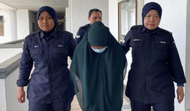 Tertuduh diiringi polis ketika meninggalkan mahkamah