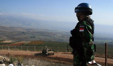 An Indonesian UN soldier based in south Lebanon, observes an Israeli army Humvee parked on the Israeli side of the Lebanese-Israeli border, 10 December 2007.  Some 1000 Indonesian peacekeeping troops serve in the United Nations Interim Force in Lebanon (UNIFIL). AFP PHOTO/ALI DIA  (Photo credit should read ALI DIA/AFP via Getty Images)