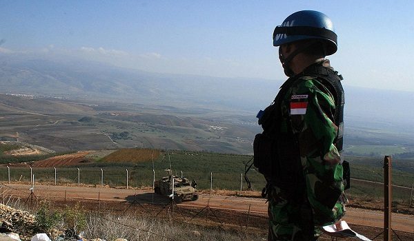 An Indonesian UN soldier based in south Lebanon, observes an Israeli army Humvee parked on the Israeli side of the Lebanese-Israeli border, 10 December 2007.  Some 1000 Indonesian peacekeeping troops serve in the United Nations Interim Force in Lebanon (UNIFIL). AFP PHOTO/ALI DIA  (Photo credit should read ALI DIA/AFP via Getty Images)