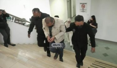 Tertuduh, diiringi pegawai SPRM ketika tiba di mahkamah