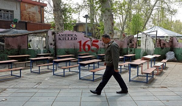 A man walks past a memorial depicting a symbolic classroom representing the Minab school children is displayed in a square in Tehran on May 3, 2026. Iran on April 28 shared a breakdown of the death toll from the deadly strike on the school on the first day of the Middle East war. Seventy-three boys and 47 girls were killed in the February 28 strike in Minab, state broadcaster IRIB and local media reported. The attack happened on the day the United States and Israel launched attacks across Iran. In retaliation, Tehran struck targets in Israel and Gulf nations. (Photo by AFP) /
