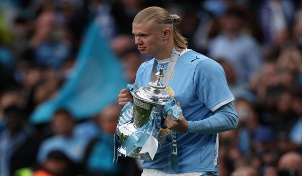 Manchester City's Norwegian striker #09 Erling Haaland holds the trophy as City players celebrate on the pitch after the English FA Cup final football match between Chelsea and Manchester City at Wembley stadium in London, on May 16, 2026. Manchester City won the game 1-0. The third FA Cup success of Guardiola's reign ended City's run of two successive defeats in the final. (Photo by Adrian Dennis / AFP) / NOT FOR MARKETING OR ADVERTISING USE / RESTRICTED TO EDITORIAL USE