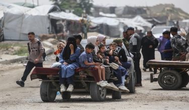 Palestinians sit on a trailer in Khan Yunis in the southern Gaza Strip on April 18, 2026. Since October 10, a fragile US-sponsored truce in Gaza has largely halted the fighting between Israeli forces and Hamas, but both sides have alleged frequent violations. (Photo by Bashar Taleb / AFP)