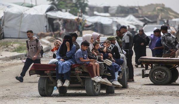 Palestinians sit on a trailer in Khan Yunis in the southern Gaza Strip on April 18, 2026. Since October 10, a fragile US-sponsored truce in Gaza has largely halted the fighting between Israeli forces and Hamas, but both sides have alleged frequent violations. (Photo by Bashar Taleb / AFP)