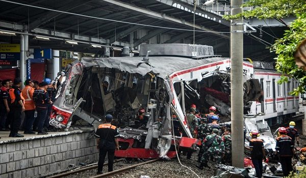 Workers clear debris at the train collision site after the locomotive of a passenger train pierced through the rear car of a commuter train at Bekasi Timur Station in Bekasi, West Java on April 28, 2026. Indonesia's president ordered an investigation on April 28 after a long-distance train smashed into a stationary commuter train overnight, killing 15 people and injuring dozens. (Photo by Rezas / AFP)