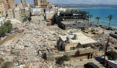 Diggers remove the rubble of buildings destroyed in Israeli strikes as they look for survivors buried underneath in the southern Lebanese coastal city of Tyre on April 21, 2026. Israeli defence minister said on April 21 that his country's campaign in Lebanon relied on both military and diplomatic pressure to disarm Iran-allied Hezbollah. Though a truce between Israel and Lebanon took effect on April 17, Israeli troops are still present and actively fighting Hezbollah militants in Lebanon's south. (Photo by Mahmoud ZAYYAT / AFP)