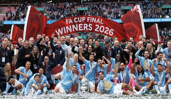 Manchester City's players and staff celebrate with the trophy on the pitch after the English FA Cup final football match between Chelsea and Manchester City at Wembley stadium in London, on May 16, 2026. Manchester City won the game 1-0. The third FA Cup success of Guardiola's reign ended City's run of two successive defeats in the final. (Photo by Adrian Dennis / AFP) / NOT FOR MARKETING OR ADVERTISING USE / RESTRICTED TO EDITORIAL USE
