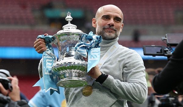 (FILES) Manchester City's Spanish manager Pep Guardiola poses with the trophy on the pitch after the English FA Cup final football match between Chelsea and Manchester City at Wembley stadium in London, on May 16, 2026. Pep Guardiola is set to bring his trophy-laden decade in charge of Manchester City to an end this weekend, according to multiple reports on Monday. Guardiola, 55, has won six Premier League titles and City's first Champions League among 20 trophies since arriving in England in 2016. (Photo by Adrian Dennis / AFP) / NOT FOR MARKETING OR ADVERTISING USE / RESTRICTED TO EDITORIAL USE